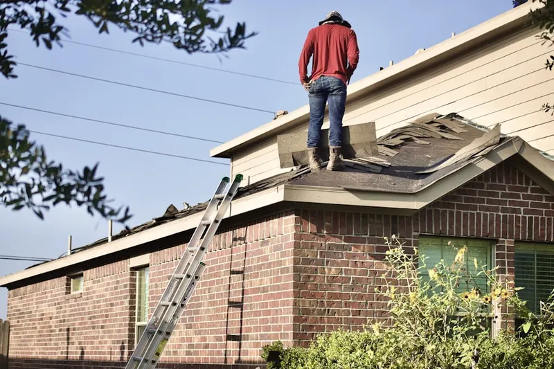 Professional roofer working on a residential roof in Grahms